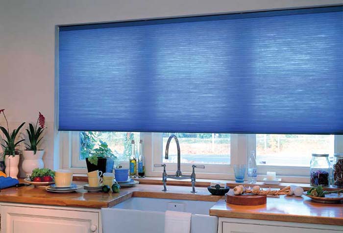 Blue roller blind in the kitchen window opening