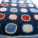 Knitted blanket of squares with a blue background