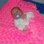 Bright blanket for the baby in the crib