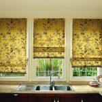 Wzorzyste zasłony Golden Roman w oknie kuchennym