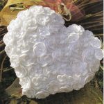 Baltas megztas širdies pagalvė su gėlėmis