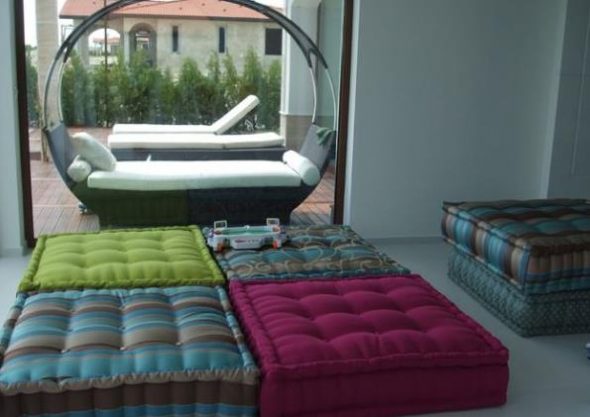 Döşemeli mobilyalar yerine yastıkları olan geniş bir oturma odası.