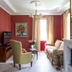 أريكة ملونة في غرفة المعيشة مع جدران بورجوندي