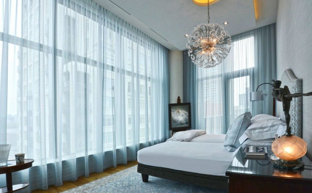 Mavi tül ile panoramik bir yatak odası penceresi dekorasyonu