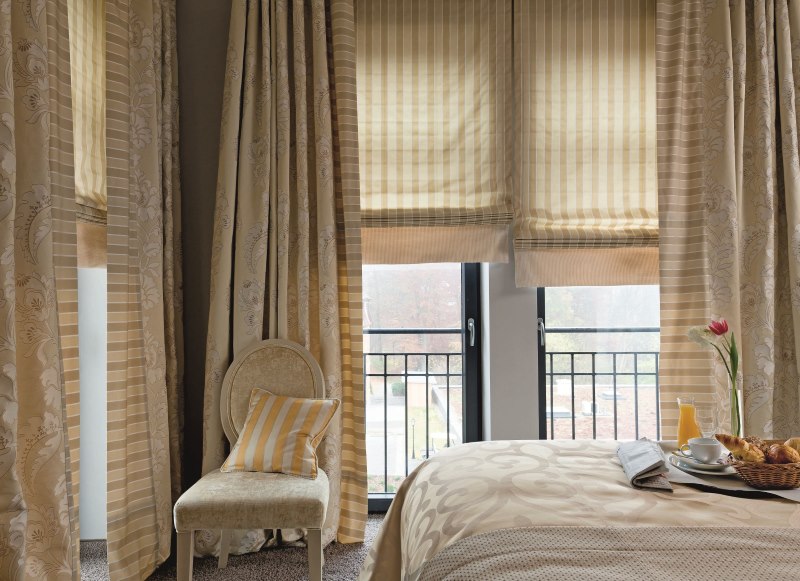Beżowe zasłony w sypialni z dwoma oknami