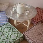 Square cushions sa sahig para sa isang komportableng tea party