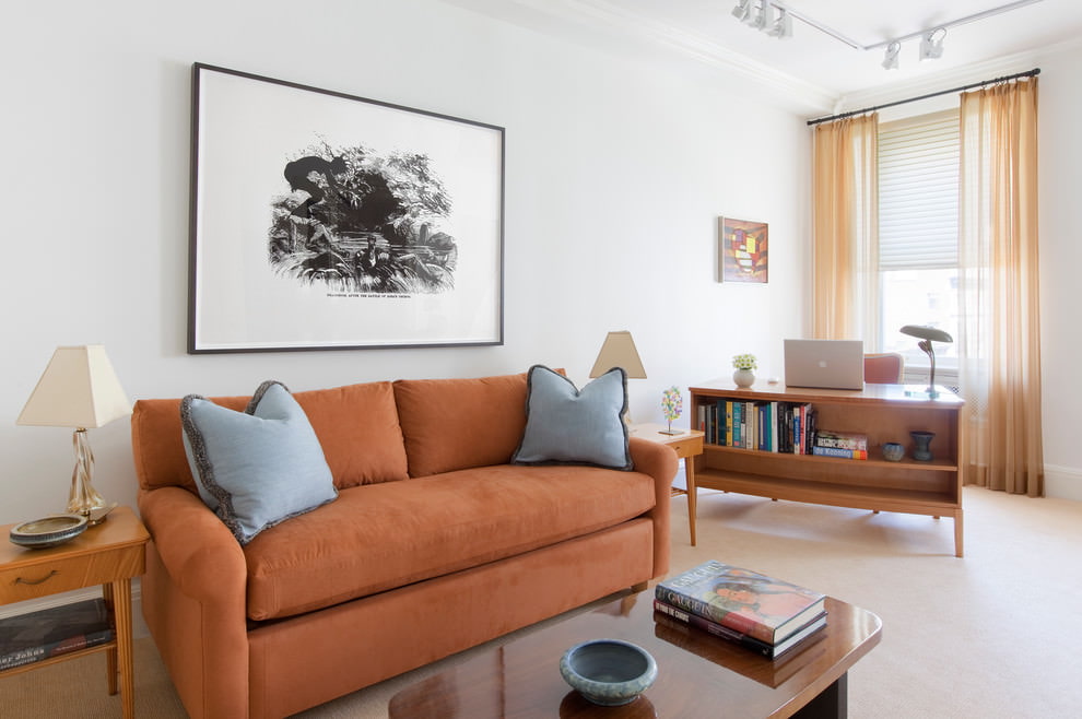 Sohva, jossa on oranssi verhoilu olohuoneessa, jossa on valkoiset seinät