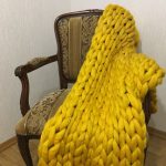 Големият плетен калъф, изработен от 100% жълта вълна, изглежда много привлекателен в интериора