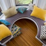 Ang mga cushions para sa sofa na malapit sa bay window