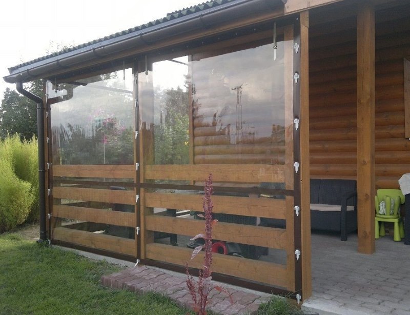 Véranda en bois d'une maison privée avec rideaux en PVC