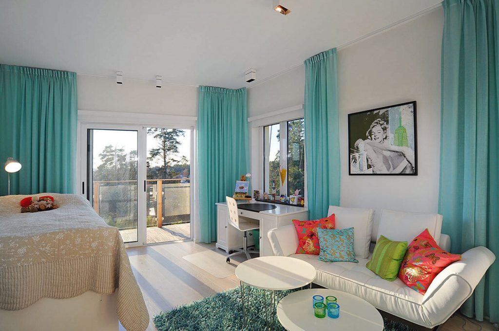 Wit meubilair in de woonkamer met turquoise gordijnen