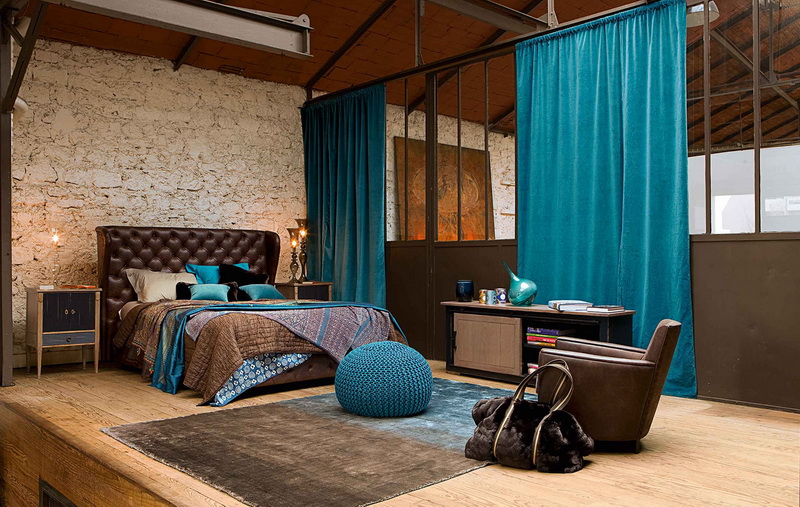 Spacious loft style bedroom with turquoise straight curtains