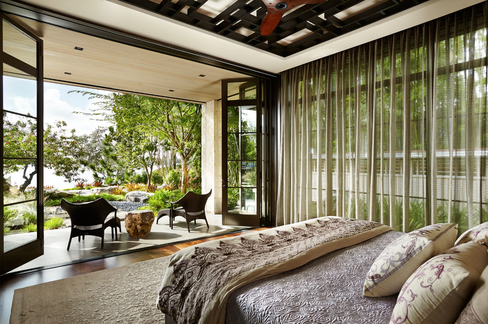 Soveværelse indvendigt med panoramavinduer i et landhus