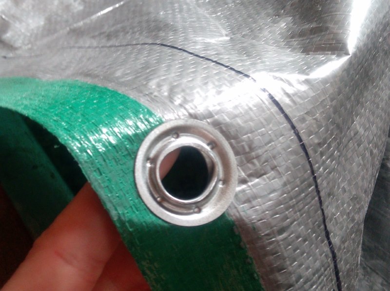 Do-it-yourself grommet on green fabric