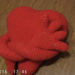 Knitted pillow with heart and hands