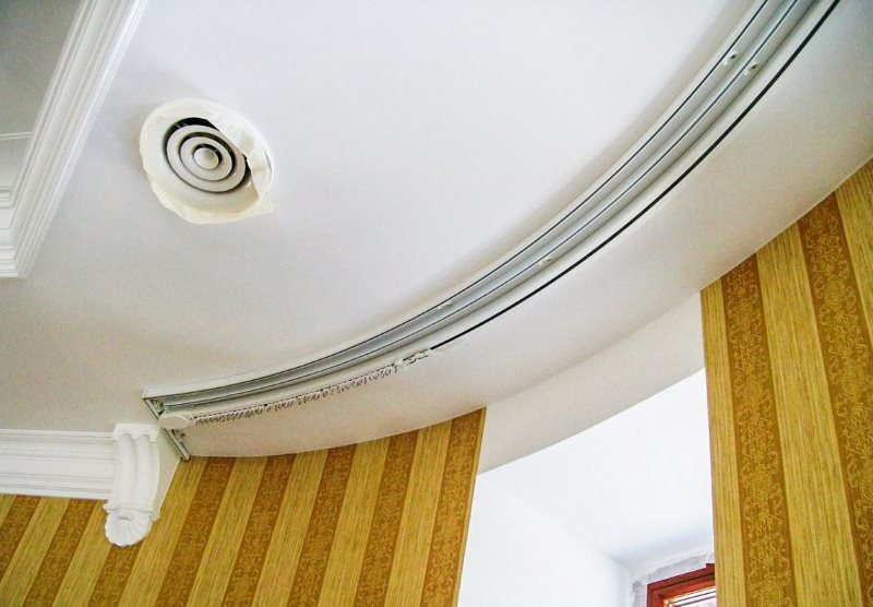 Arched profile cornice on the ceiling in the bay window