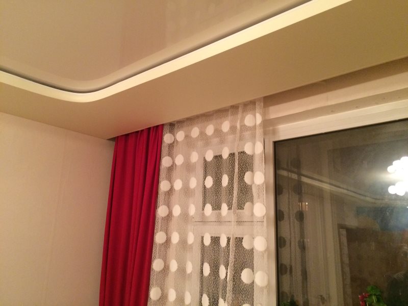 Curtains on the hidden cornice in the living room with a stretch ceiling