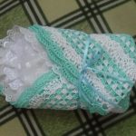 A beautiful white and green blanket will suit a boy and a girl.