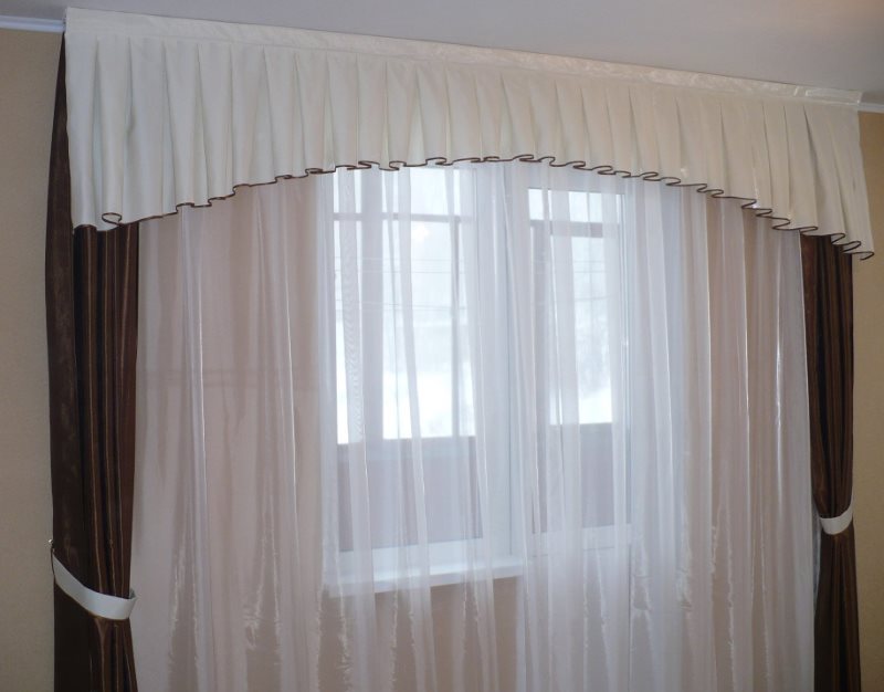 White pelmet with pleats on the window of a real apartment