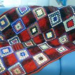 Plaid on the sofa of grandmother's knitted squares, combined with woolen squares