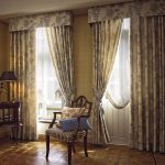 Straight curtains in the living room with two windows with a hard lambrequin.
