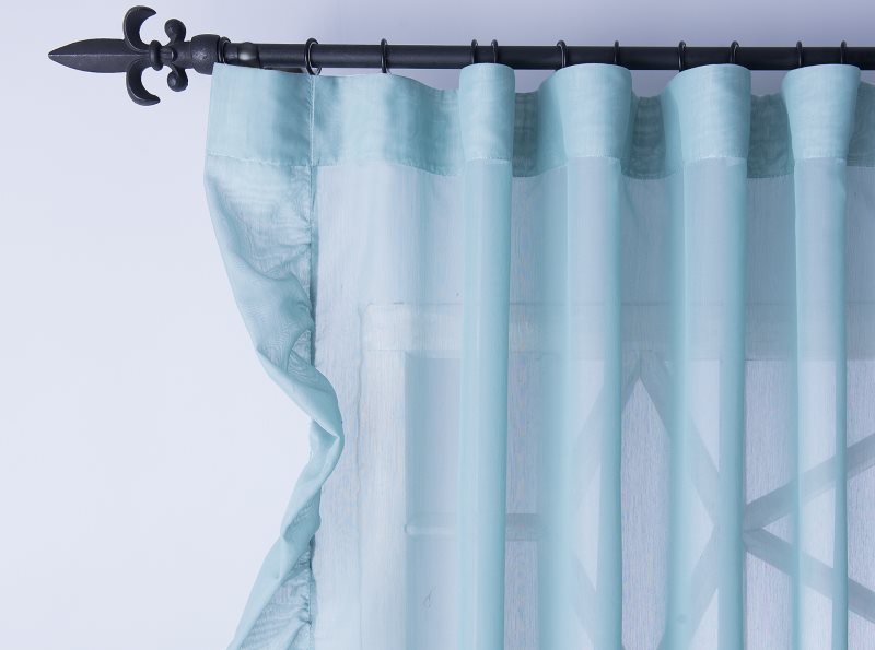 Sheer polyester curtain on forged cornice