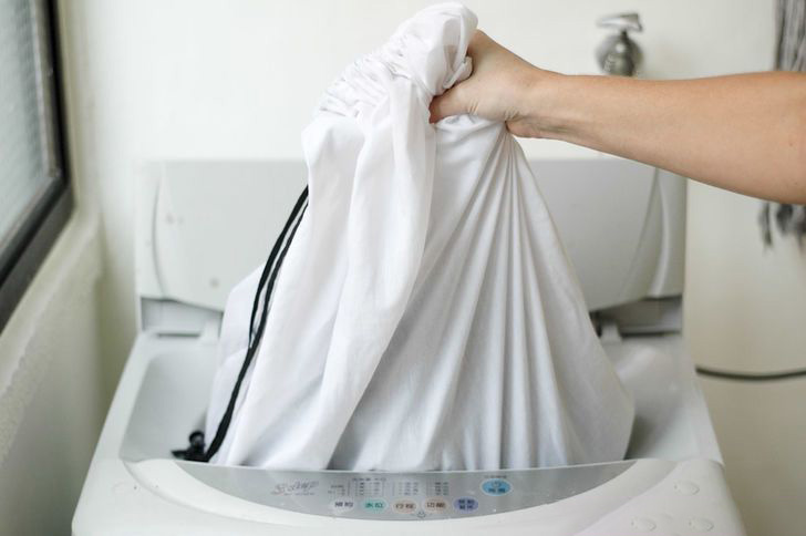 Ładowanie zasłon w maszynie w torbie do prania