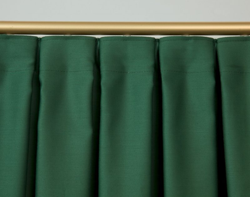 Cross folds on the curtain of dark green material