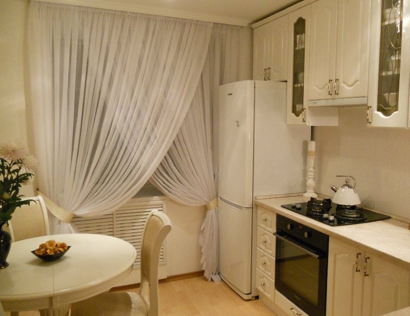Bílé krajkové záclony na kuchyňské okno