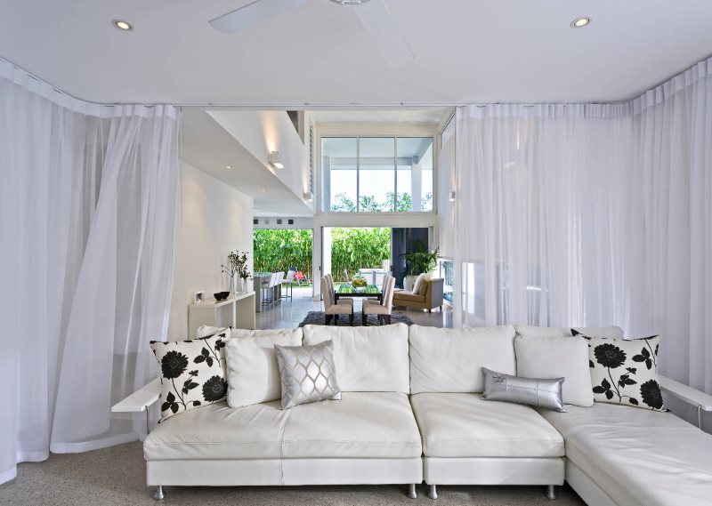 Zdobení interiéru obývacího pokoje bílými závěsy