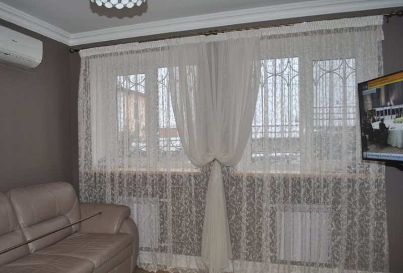 Dva bílé tylu v okně obývacího pokoje