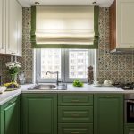 Римската завеса в интериора на кухнята със зелени мебели