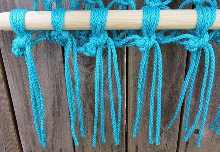 Tkaní uzlů tyrkysové lana na dřevěnou hůl