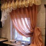 Zasłony z kolorowego tiulu w oknie kuchennym