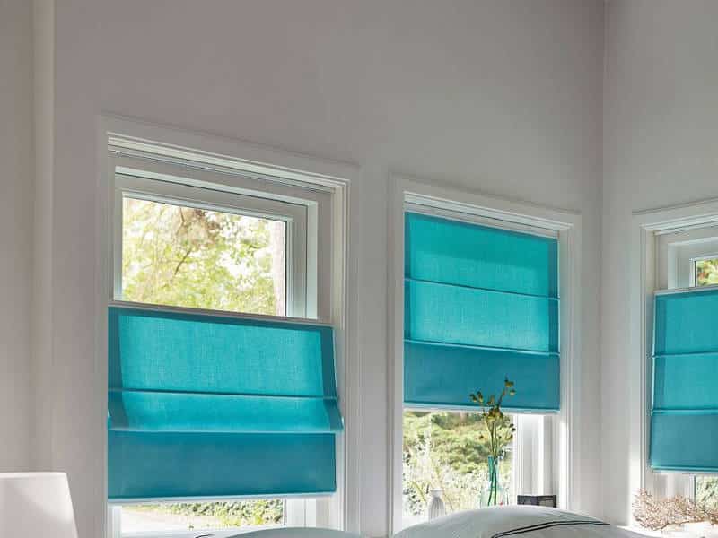 Blauwe vouwgordijnen op kunststof ramen
