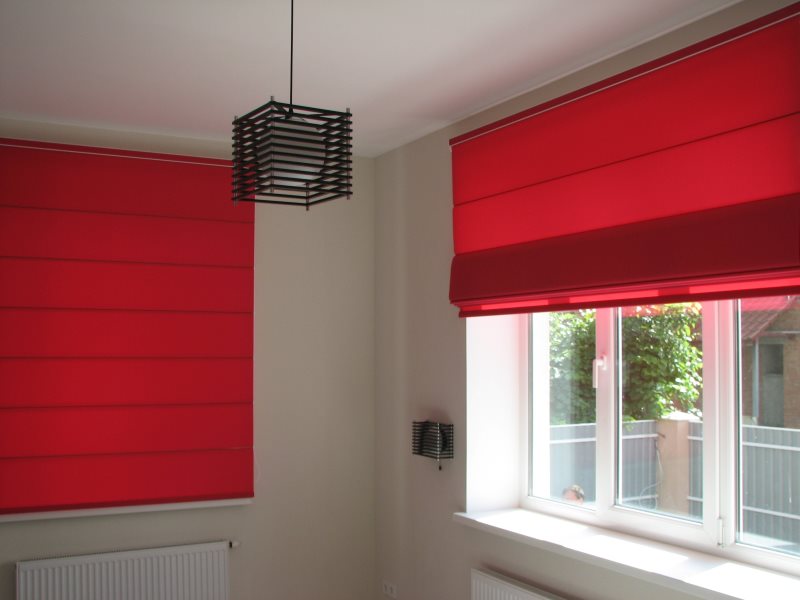Red roman blinds on the windows of a private house