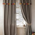 Gray curtains on the rings with multicolored tassels