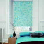Turquoise rolled curtain with a print in the bedroom