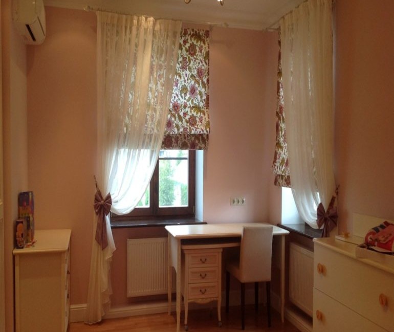 Desk in front of windows with roman blinds