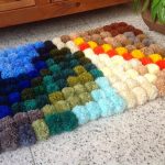 colored bedside rug made of pompons