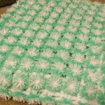 white-green blanket of pompons