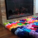 rug of pompons by the fireplace